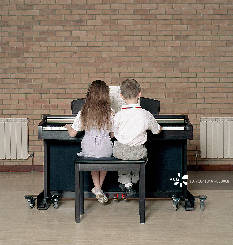 孩子们弹钢琴二重奏图片素材