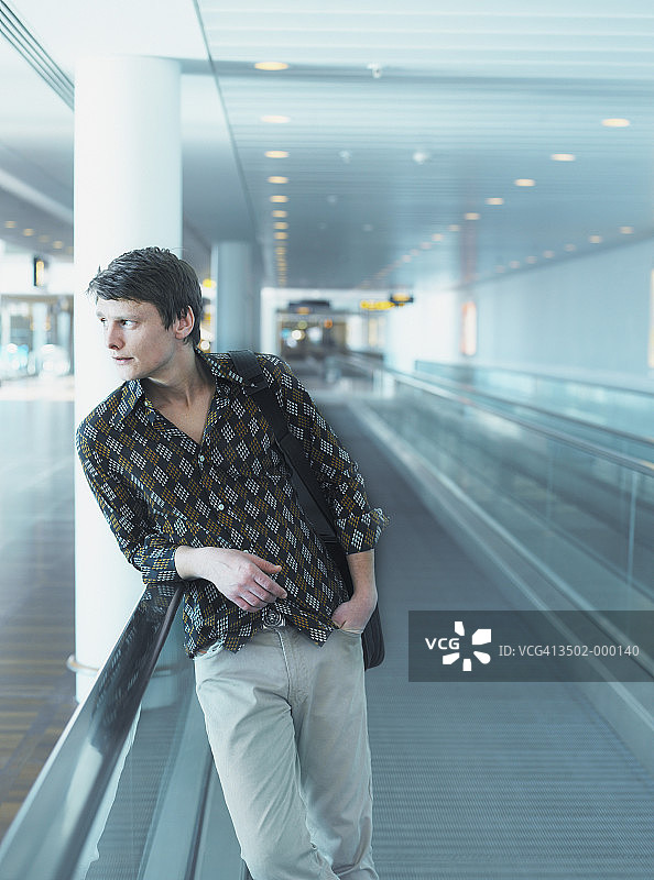 男人站在自动人行道上图片素材