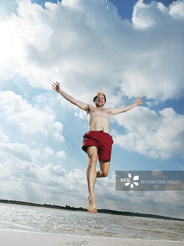 在海滩上跳跃的男人图片素材