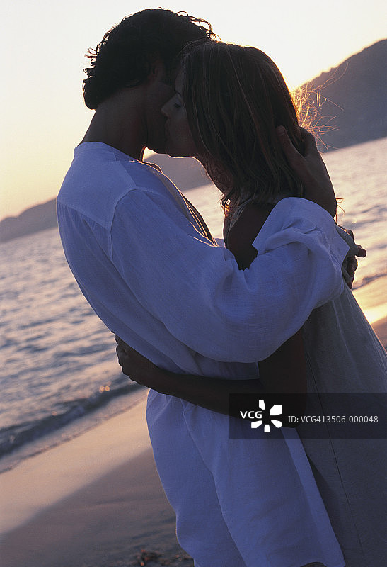 情侣在日落时分的海滩上图片素材