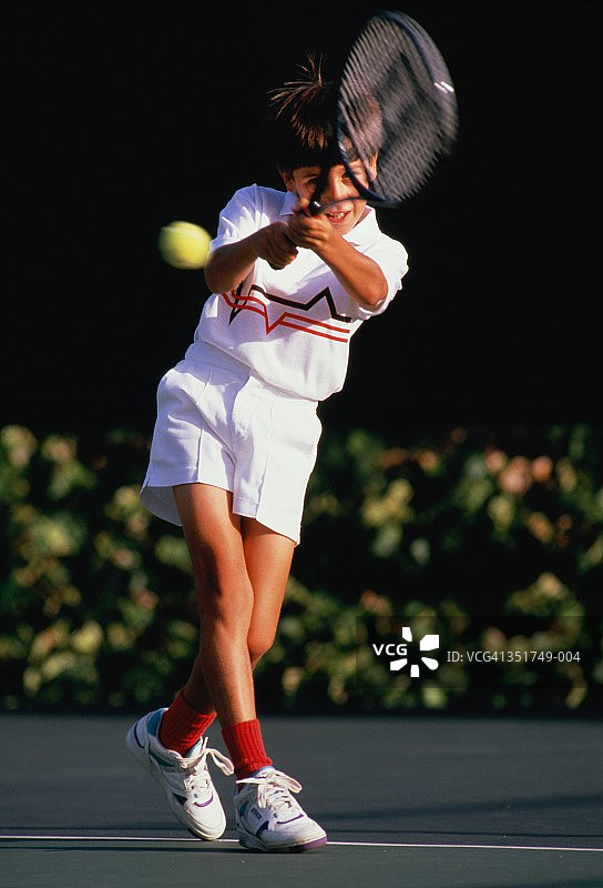 男孩（9-11岁）打网球，反手回球图片素材