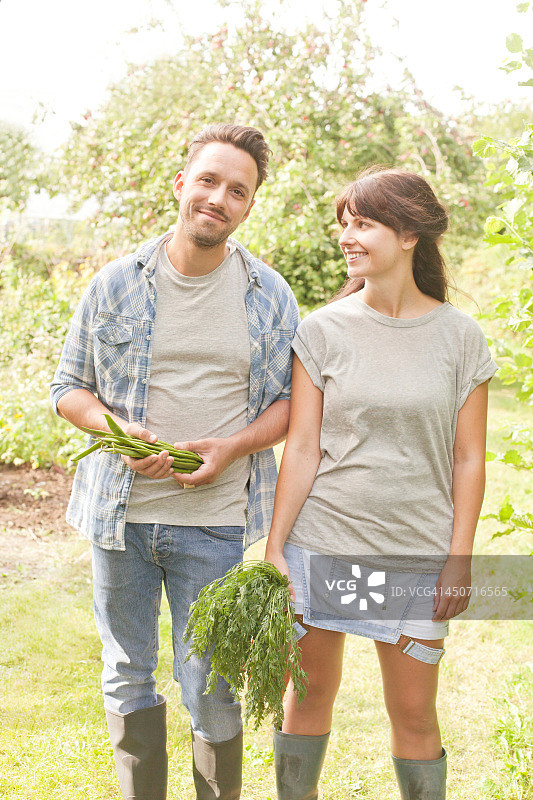 夫妇在分配的入口处拿着蔬菜图片素材