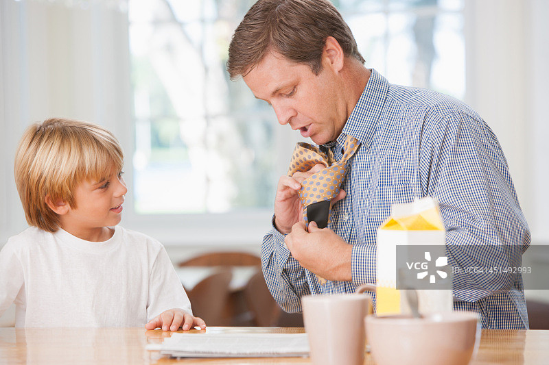 男人在厨房里和年轻男孩一起系领带图片素材