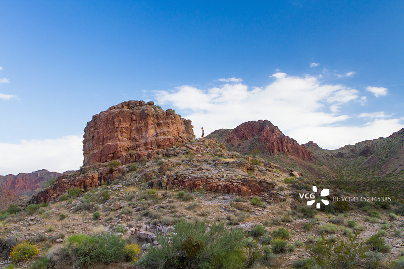 男人攀登红色岩石山图片素材