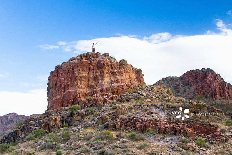 男人攀登红色岩石山图片素材