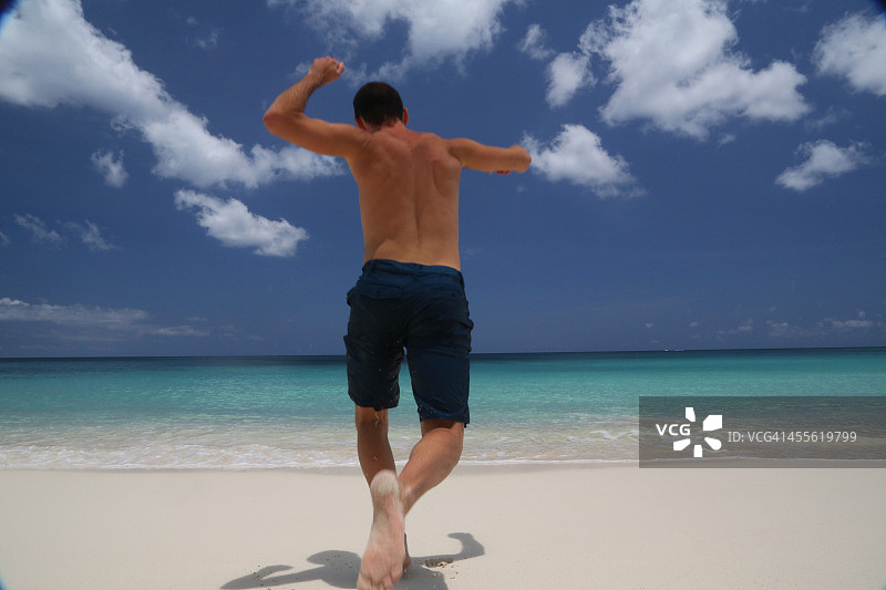 男人奔向大海，后视图图片素材