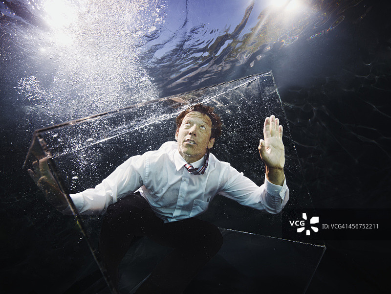 水下视角：玻璃箱中的商人图片素材