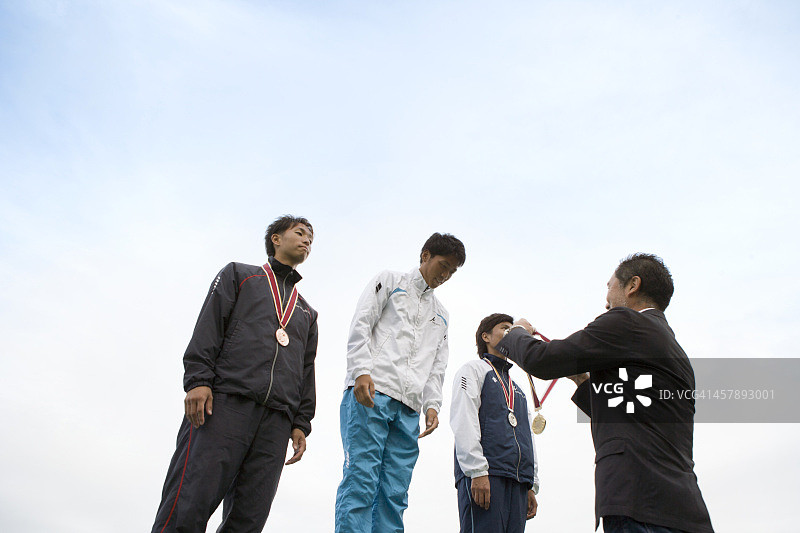 运动员在领奖台上接受奖牌图片素材