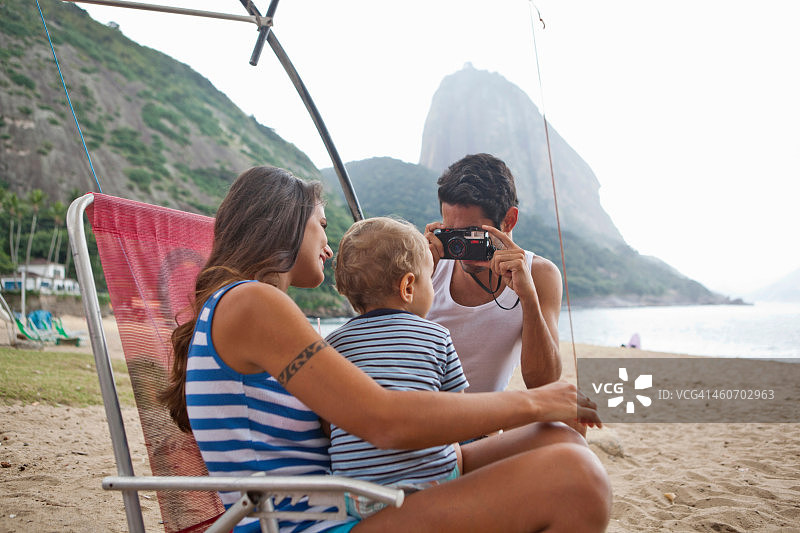 男人在巴西里约热内卢为椅子上的母子拍照图片素材