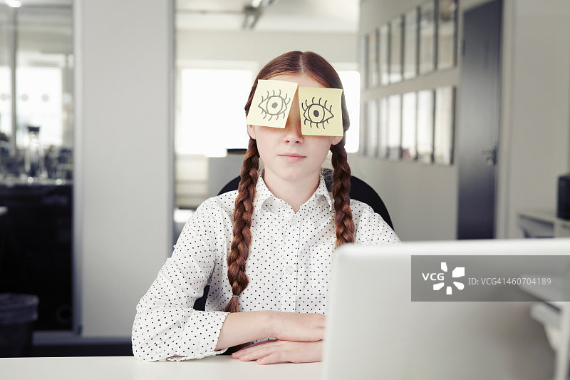 在办公室里，眼睛被便利贴遮住的女孩图片素材