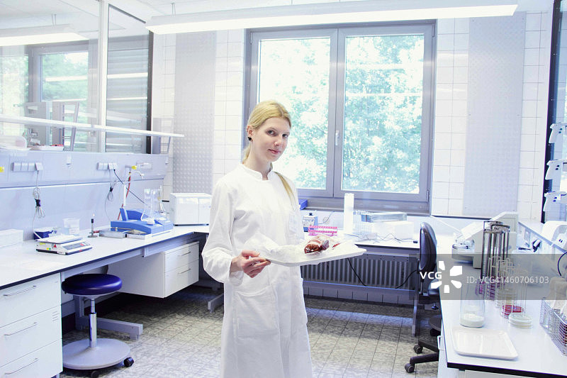 端着托盘看向镜头的科学家图片素材