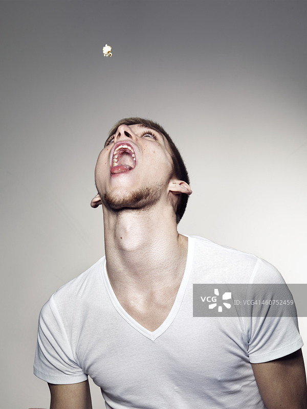 年轻男人玩爆米花图片素材