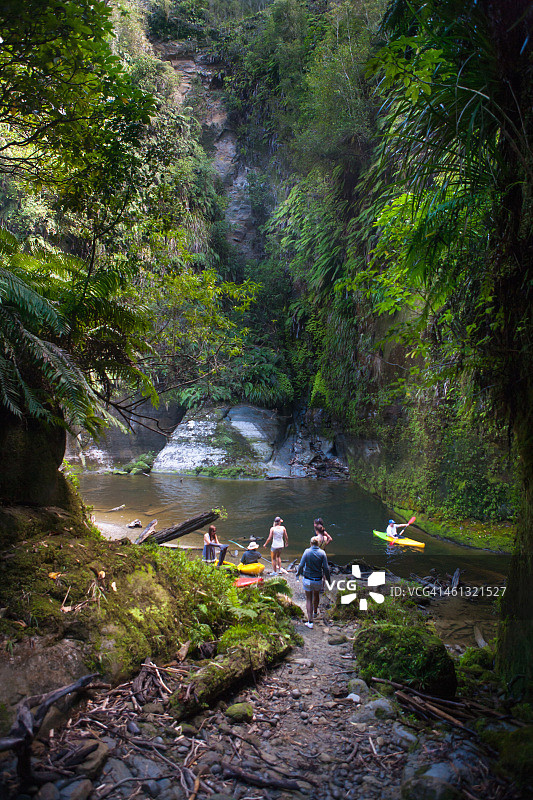 在瓦卡霍罗划皮划艇穿过蕨类覆盖的石窟图片素材