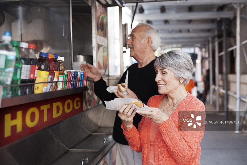 老年夫妇在街头摊贩处购买食物图片素材