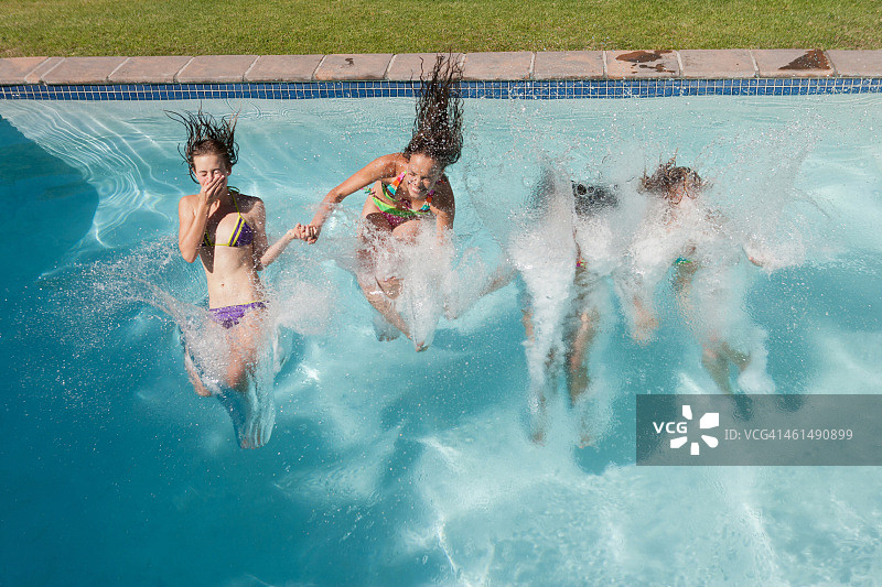 四个穿比基尼的少女跳入室外游泳池图片素材