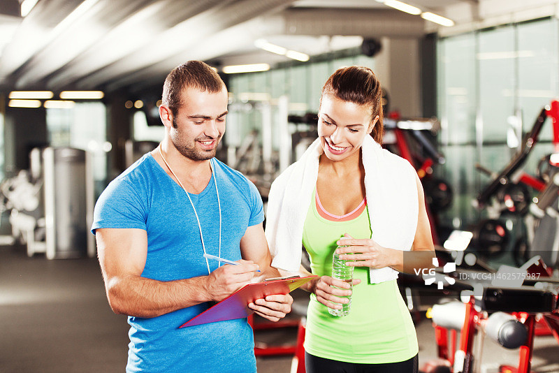 女人在健身房与私人教练图片素材