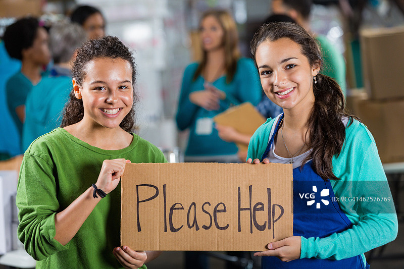 青少年志愿者在食物银行举着“请帮助”的牌子图片素材
