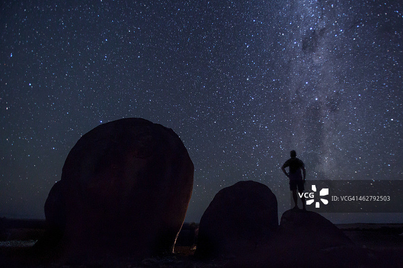 在澳大利亚，望着星空的岩石上的男人图片素材