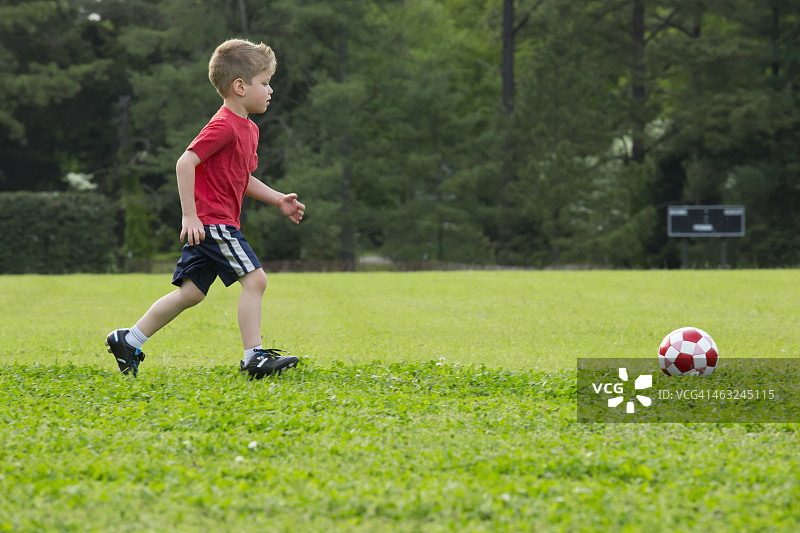 混血男孩踢足球图片素材