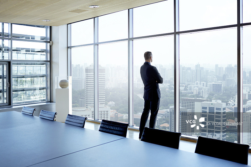 商人眺望窗外的城市天际线图片素材