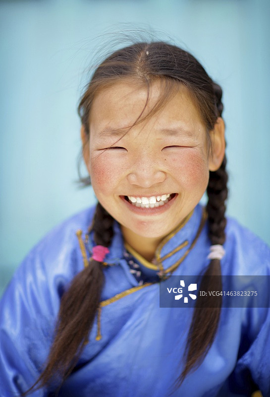 对着蓝色背景微笑的游牧女孩图片素材