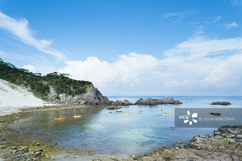 在平静的海湾海滩上划皮划艇的人们图片素材