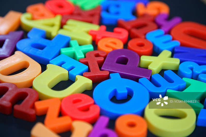 黑色背景上的彩色字母磁铁图片素材