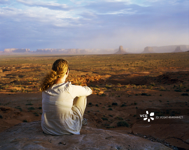 俯瞰有沙尘暴的沙漠景观的女子图片素材