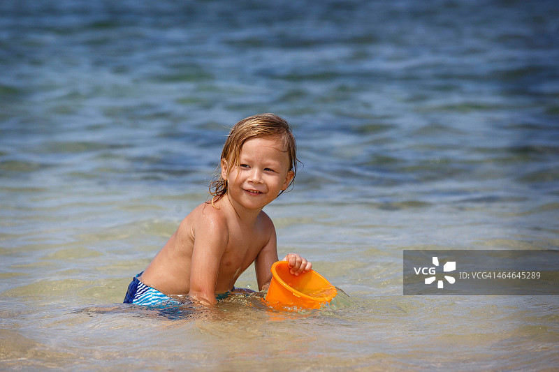 男孩在夏威夷海滩玩桶图片素材