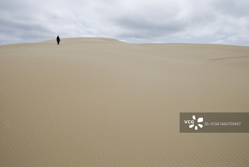 独自走在远处沙丘上的女人图片素材