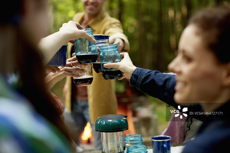 树林中的营地空地，人们围坐在桌旁图片素材