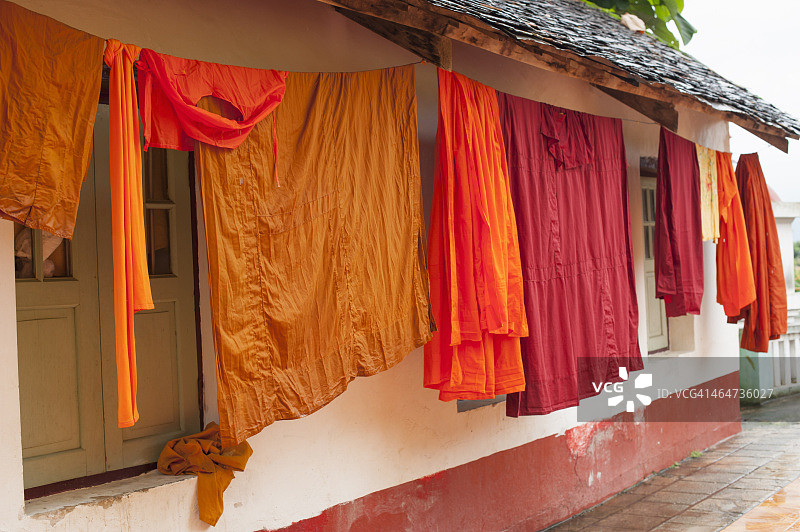 缅甸掸邦景栋县佛教寺院外悬挂的长袍图片素材