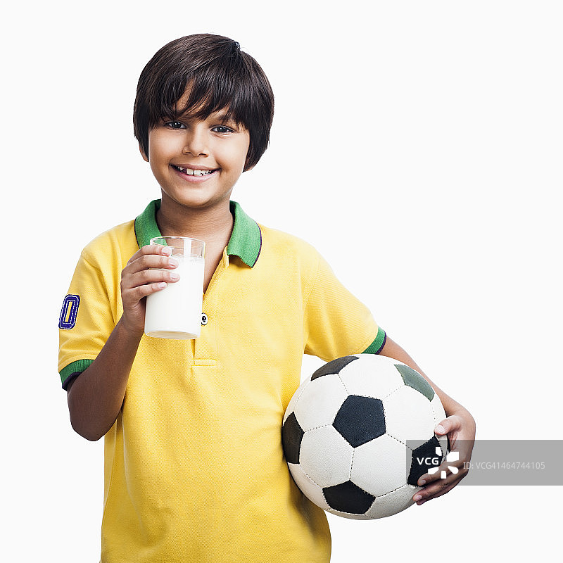 男孩拿着一杯牛奶和一个足球图片素材