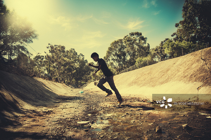 青少年跑过露天污水沟图片素材