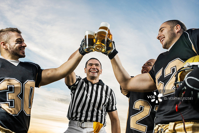 美式橄榄球运动员们举杯庆祝胜利图片素材