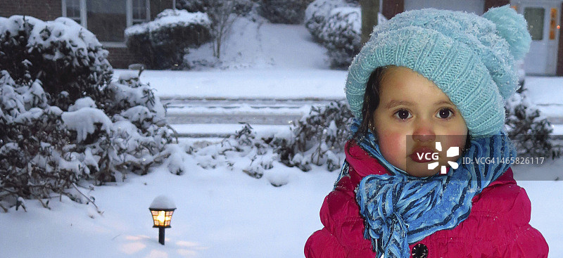 独自站在雪地里的女婴肖像图片素材
