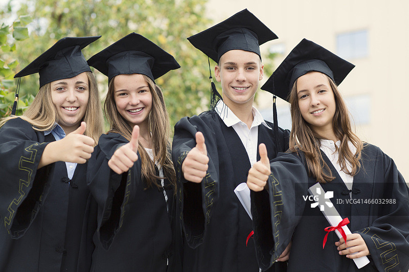 毕业典礼上竖起大拇指的青少年同学图片素材