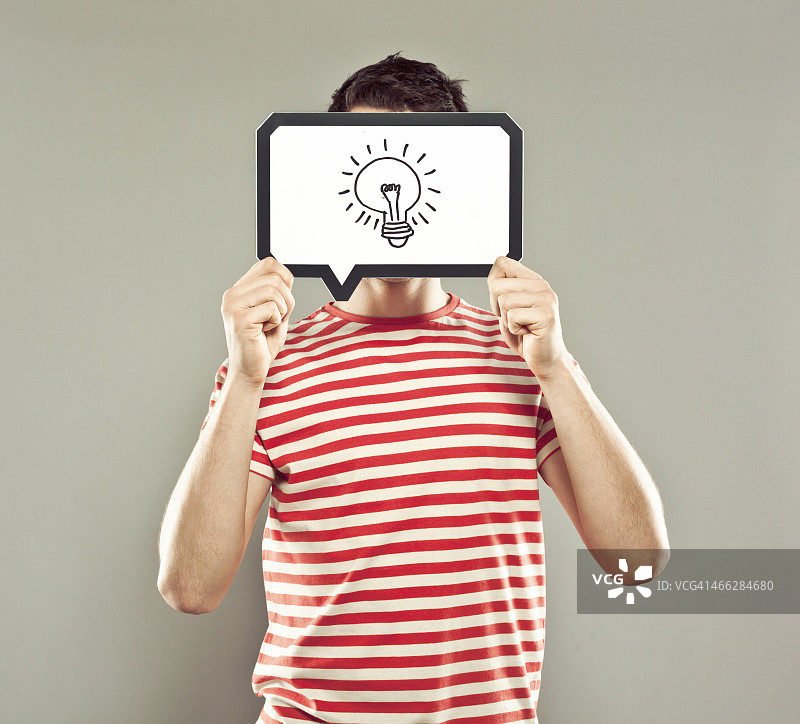 手持灯泡对话气泡的年轻男人图片素材