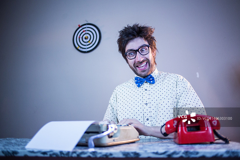 非常快乐的书呆子在打字机上打字图片素材