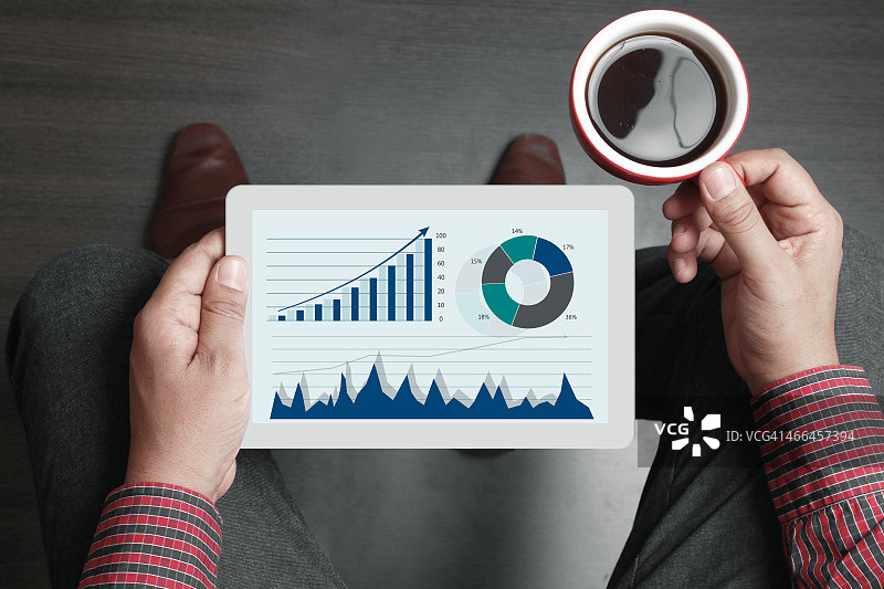 商人手持茶杯和数字平板电脑图片素材