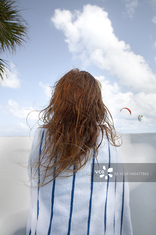 女孩站在阳台上，裹着毛巾图片素材