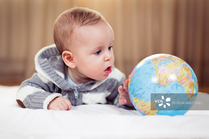 抱着地球仪的婴儿图片素材