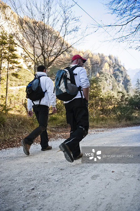 徒步旅行的朋友们背着背包在山中行走图片素材