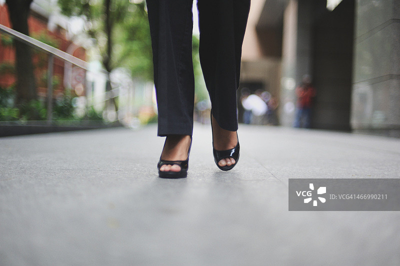 低角度看穿工装裤和黑色高跟鞋的女人图片素材