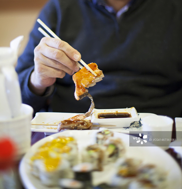 男人吃照烧三文鱼图片素材