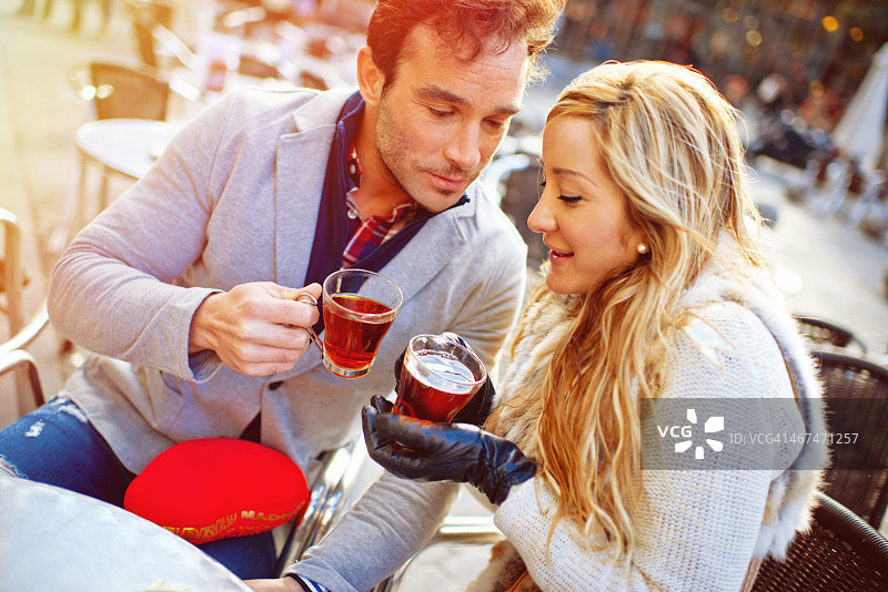 情侣在马德里户外咖啡馆喝热茶图片素材