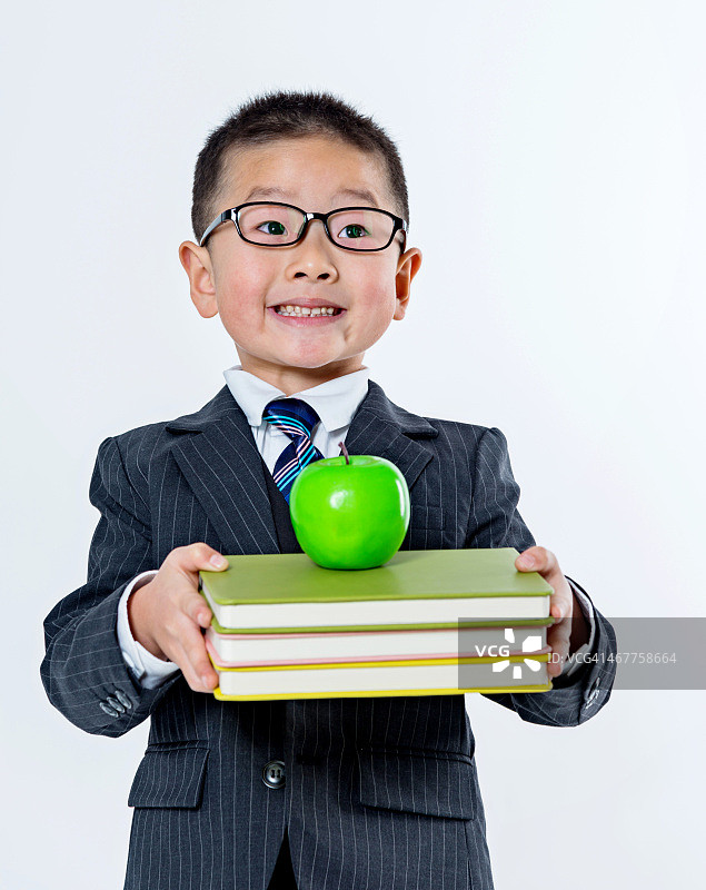 男孩抱着书和苹果图片素材