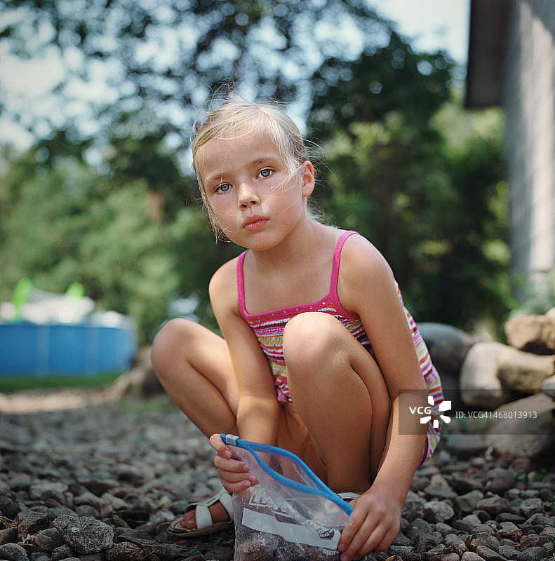 在院子里捡石头的小女孩图片素材