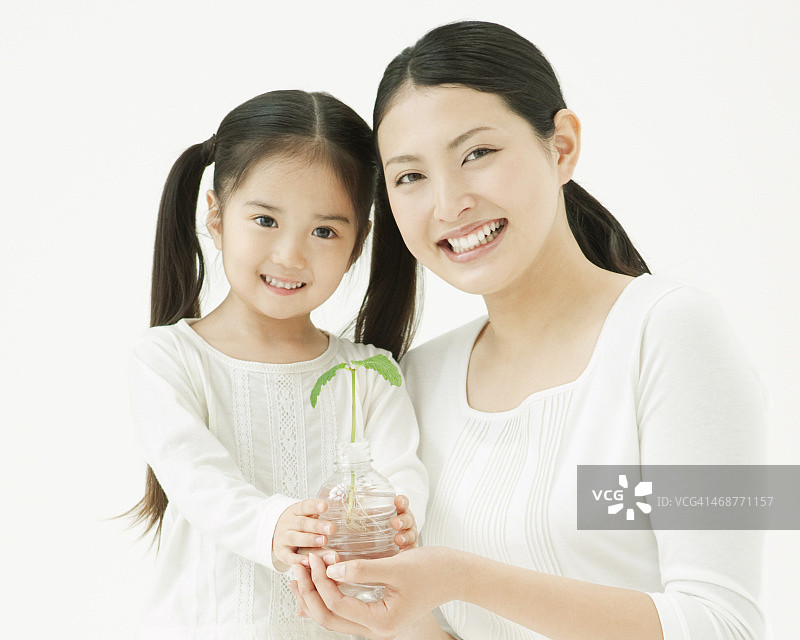 母亲和女儿拿着树苗图片素材