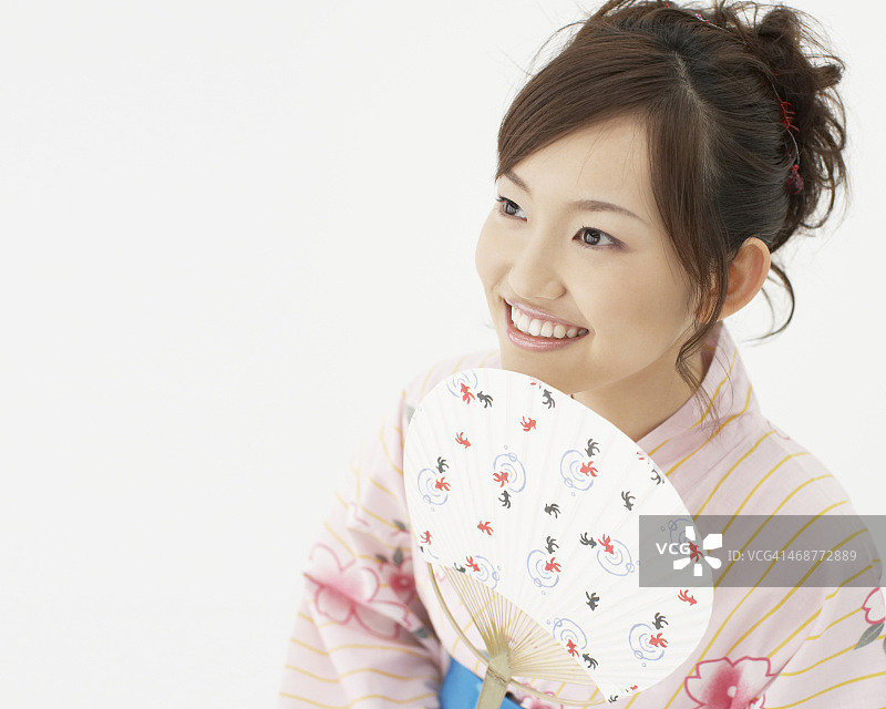 快乐的女人穿着和服拿着扇子图片素材